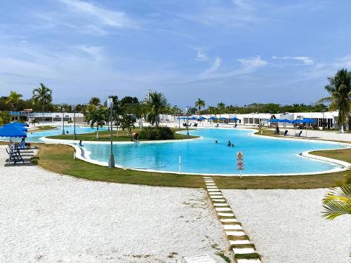 een zwembad in een resort met mensen erin bij Beach villa with cozy terrace in Río Hato