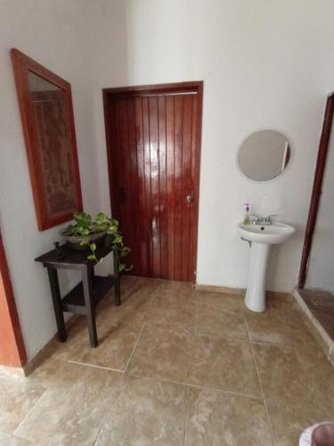 baño con lavabo y puerta de madera en casa bambú, en Palenque