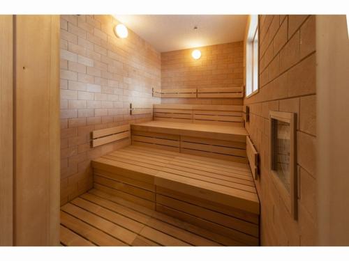 an empty sauna with wooden benches and a window at HOTEL OLE INN in Shizuoka