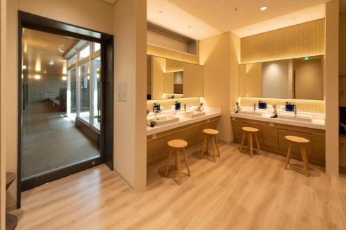 ein Badezimmer mit drei Waschbecken und zwei Hockern in der Unterkunft HOTEL OLE INN in Shizuoka