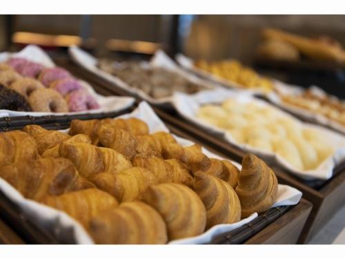 a display of different types of pastries in trays at HOTEL OLE INN in Shizuoka