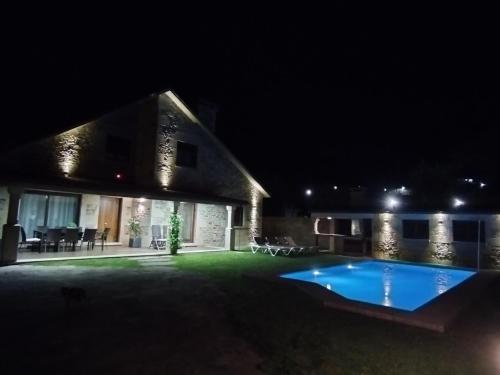 uma casa com piscina à noite em VILLA A CANLE em Catoira