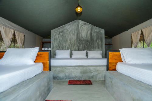 a bedroom with two beds with white pillows at Yala Wild Hut - Yala in Tissamaharama