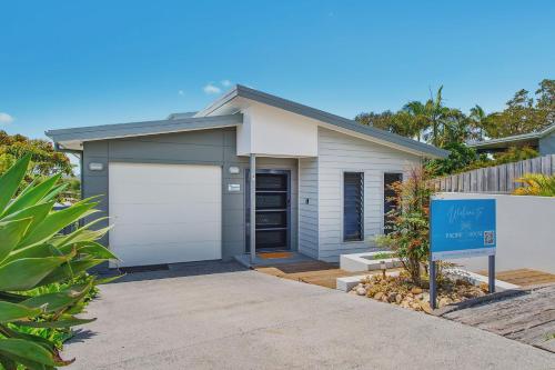 a house with a garage with a sign in front of it at Pacific House in Crescent Head