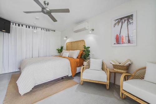 a bedroom with a bed and a chair and a fan at Pacific House in Crescent Head