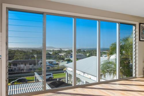 a view from the balcony of a house with large windows at Pacific House in Crescent Head