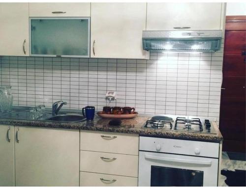 a kitchen with a sink and a stove top oven at Studio appartment beach front in Harqalah