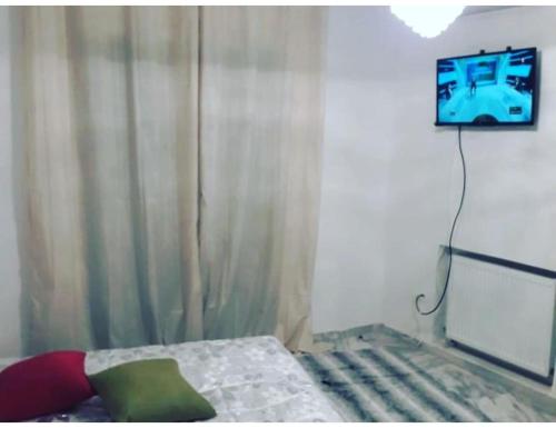a bedroom with a bed and a tv on the wall at Studio appartment beach front in Harqalah