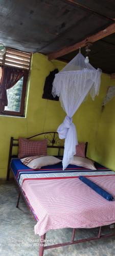 1 dormitorio con 1 cama con sombrilla en LawangInn- Restaurant-Guesthouse(B&B), en Bukit Lawang