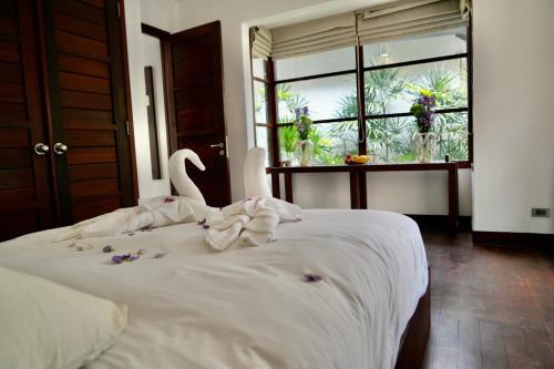 een slaapkamer met een wit bed met bloemen erop bij 3 Bedroom Seaview Villa Halo on Beachfront Resort in Koh Samui 