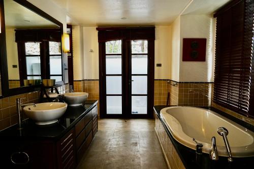 een grote badkamer met 2 wastafels en een bad bij 3 Bedroom Seaview Villa Halo on Beachfront Resort in Koh Samui 