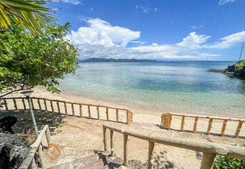 a view of a beach with a wooden fence at Villa Angelina Luxury Suites in Dapitan