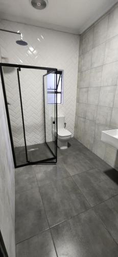 a bathroom with a toilet and a sink and a mirror at Livingwaters Self-Catering Accommodation in Ermelo