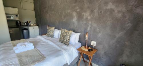 - une chambre avec un lit et une table avec une table de chevet dans l'établissement Livingwaters Self-Catering Accommodation, à Ermelo