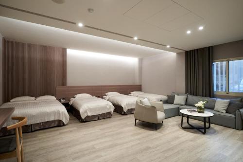 斗南Yung An Business Hotel的一间医院间,配有两张床、一张沙发和一张桌子
