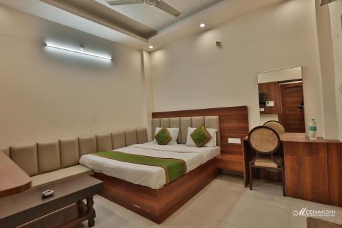 a bedroom with a bed and a desk and a chair at Hotel Haridev in Roorkee
