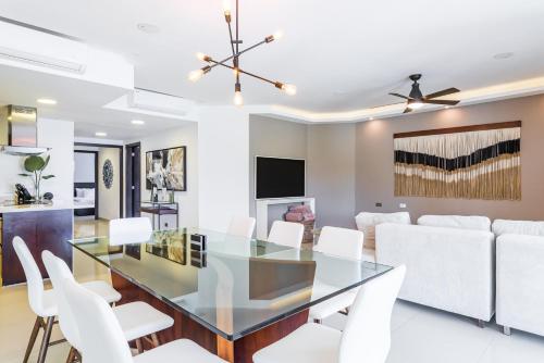 a dining room with a glass table and white chairs at Mareazul Beach Front Condos At playa del Carmen in Playa del Carmen