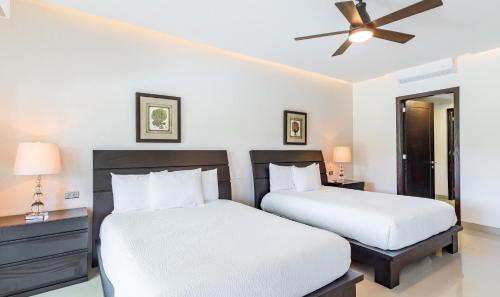a bedroom with two beds and a ceiling fan at Mareazul Beach Front Condos At playa del Carmen in Playa del Carmen