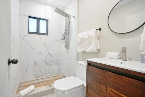 a bathroom with a shower and a toilet and a sink at Elegant Brickell Miami Apartment in Miami