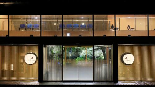 - une vue sur un bâtiment avec des portes et des chaises dans l'établissement Yutorelo Nasushiobara, à Nasushiobara