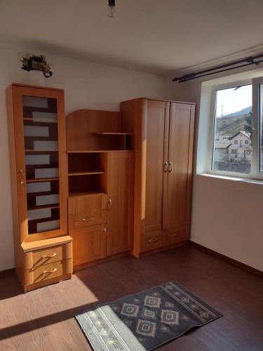 Cette chambre comprend une armoire en bois et une fenêtre. dans l'établissement Maris, à Sângeorz-Băi