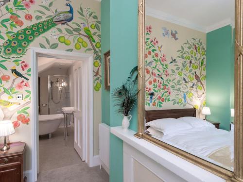 a bedroom with a mirror and a bathroom with a tub at The Counting House in Wirksworth