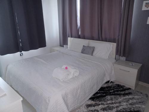 a bedroom with a white bed with a towel on it at Апартамент за гости Рамона Севлиево 2-спални apartment two bedrooms Sevlievo in Sevlievo