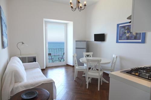 een woonkamer met een bank en een tafel met uitzicht op de oceaan bij Appartamenti Giudecca - by Vacation Service in Cefalù