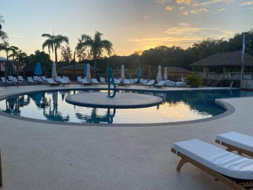 a large pool with chairs and umbrellas in a resort at Blue Dream Paradise - Résidence plage & piscine in Grand-Bourg