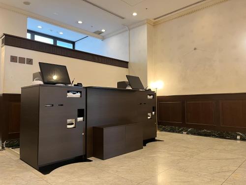 Plaza Hotel Premier في فوكوكا: مكتب به مكتب وبه لاب توب عليه