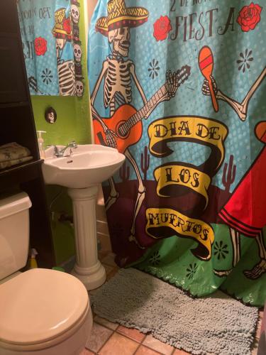 a bathroom with a toilet and a sink and a shower curtain at Castle Zoe in Vallejo