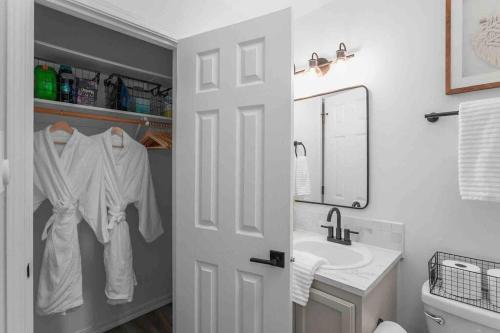 a white bathroom with a sink and a mirror at Private Newly Renovated Studio w private Parking! in Portland
