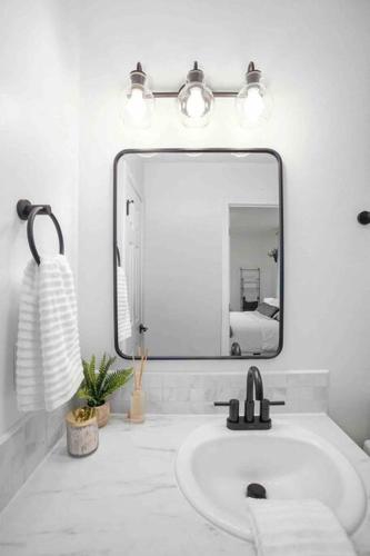 a white bathroom with a sink and a mirror at Private Newly Renovated Studio w private Parking! in Portland