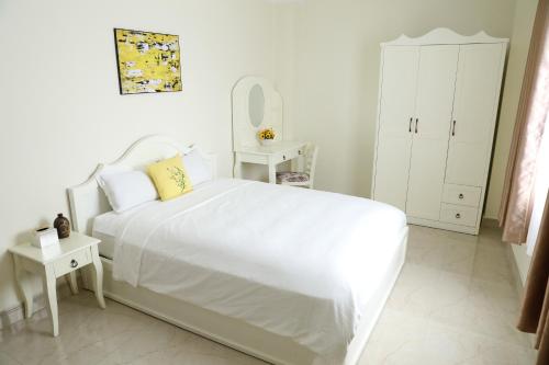 a white bedroom with a white bed and a mirror at Thành Vinh Hotel & Apartment in Ho Chi Minh City