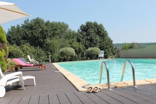 une piscine avec trois pantoufles sur le sol à côté dans l'établissement Le Cireysou - Secluded farmhouse with large private pool and grounds, à Saint-Germain-et-Mons