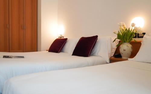 リミニにあるHotel Sunsetのベッド2台とソファが備わる客室です。