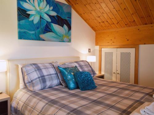 een slaapkamer met een bed met blauwe kussens en een schilderij aan de muur bij Pine View in Belton