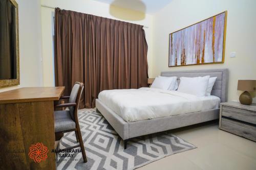 a hotel room with a bed and a desk and a desk at Alashrafia Saray - Wonderful 1BR in Sports City in Dubai