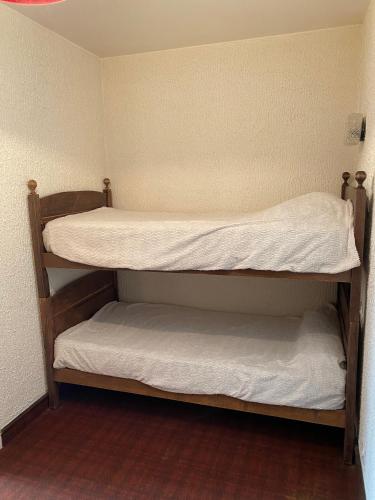 two bunk beds in a small room at Motel - location studio 4 personnes in Morbier