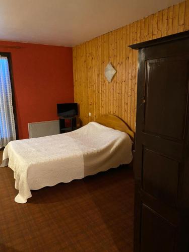 a bedroom with a bed and a dresser and a television at Motel - location studio 4 personnes in Morbier