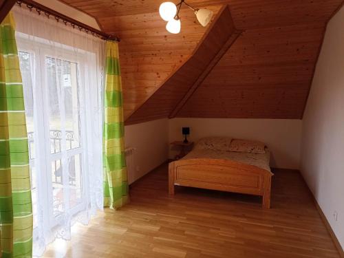 a bedroom with a bed and a large window at Kazikówka 