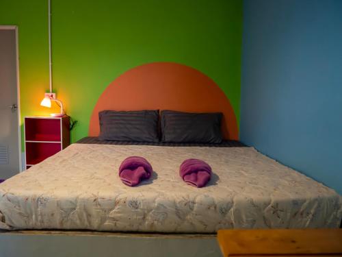 a bed with two pink pillows on top of it at Cat Bungalow in Ko Lanta
