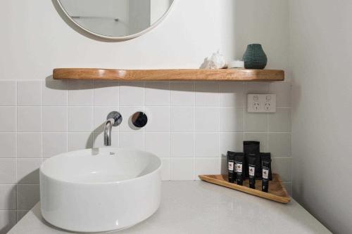 a bathroom with a white sink and a mirror at Reflections Seal Rocks - Holiday Park in Smiths Lake