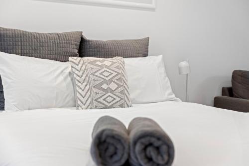 a bedroom with a white bed with pillows at Moody's Motel in Blairgowrie