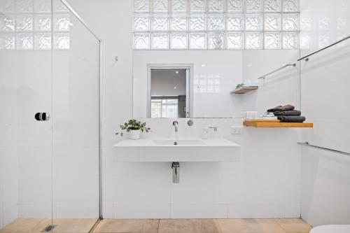 a white bathroom with a sink and a window at Moody's Motel in Blairgowrie