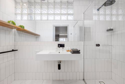 a white bathroom with a sink and a shower at Moody's Motel in Blairgowrie