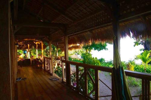 eine Veranda eines Hauses mit Meerblick in der Unterkunft The Sleepy Lagoon Beach House in Hitokalak