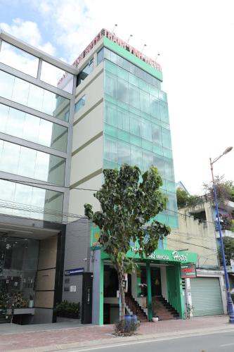 a building with a tree in front of it at Thành Vinh Hotel & Apartment in Ho Chi Minh City