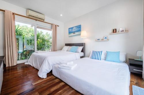 - deux lits et un canapé dans une chambre avec fenêtre dans l'établissement Private Pool Villa•4BR•PATTAYA, à Ban Rong Po