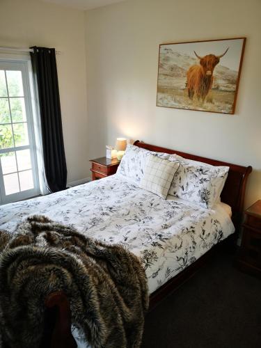 a bedroom with a bed with a bull on the wall at Hilltop Haven in Tinopai